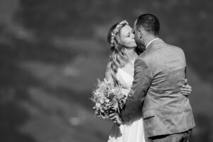 Hochzeit Bergshooting Christina und Michael - Brautpaar steht auf einem Berg in der Natur und küsst sich